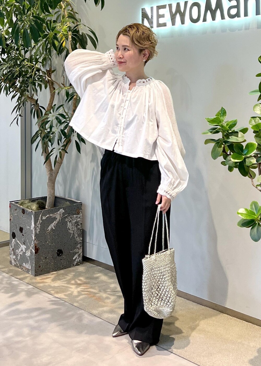 ブラック系のその他パンツ、シルバー系のトートバッグ、ホワイト系のシャツ/ブラウスを着用したレディースの夏コーディネートの3枚目の写真