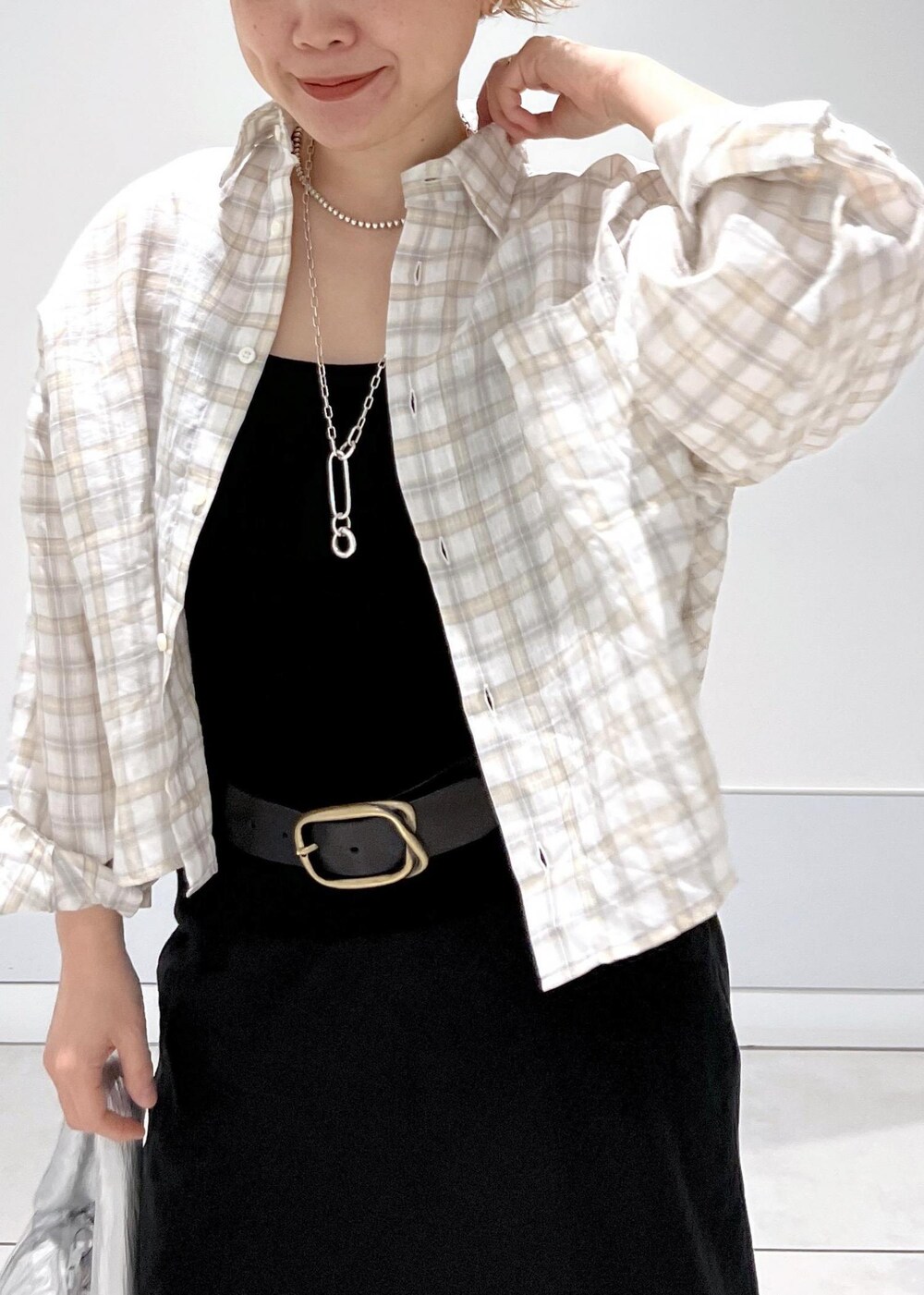 シルバー系のハンドバッグ、ホワイト系のサンダル、ブラック系のスカートを着用したレディースの春コーディネートの5枚目の写真