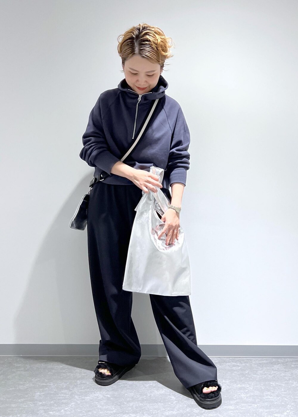 ブルー系のスラックス、グレー系のパーカー、シルバー系のトートバッグを着用したレディースの夏コーディネートの4枚目の写真