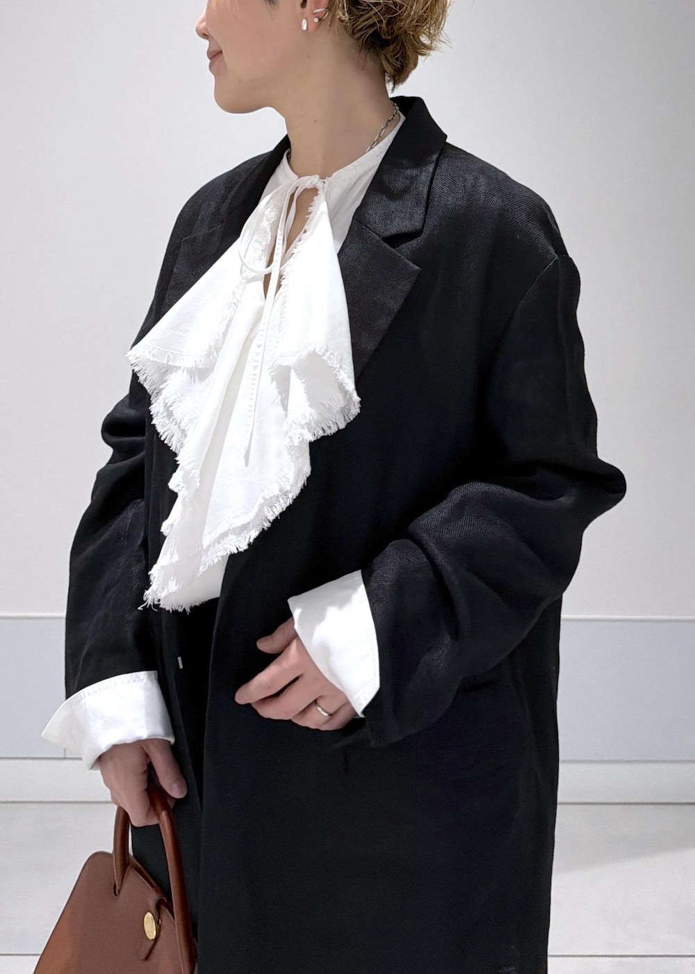 ブラック系のスカート、ブラック系のテーラードジャケット、ホワイト系のシャツ/ブラウスを着用したレディースの冬コーディネートの6枚目の写真