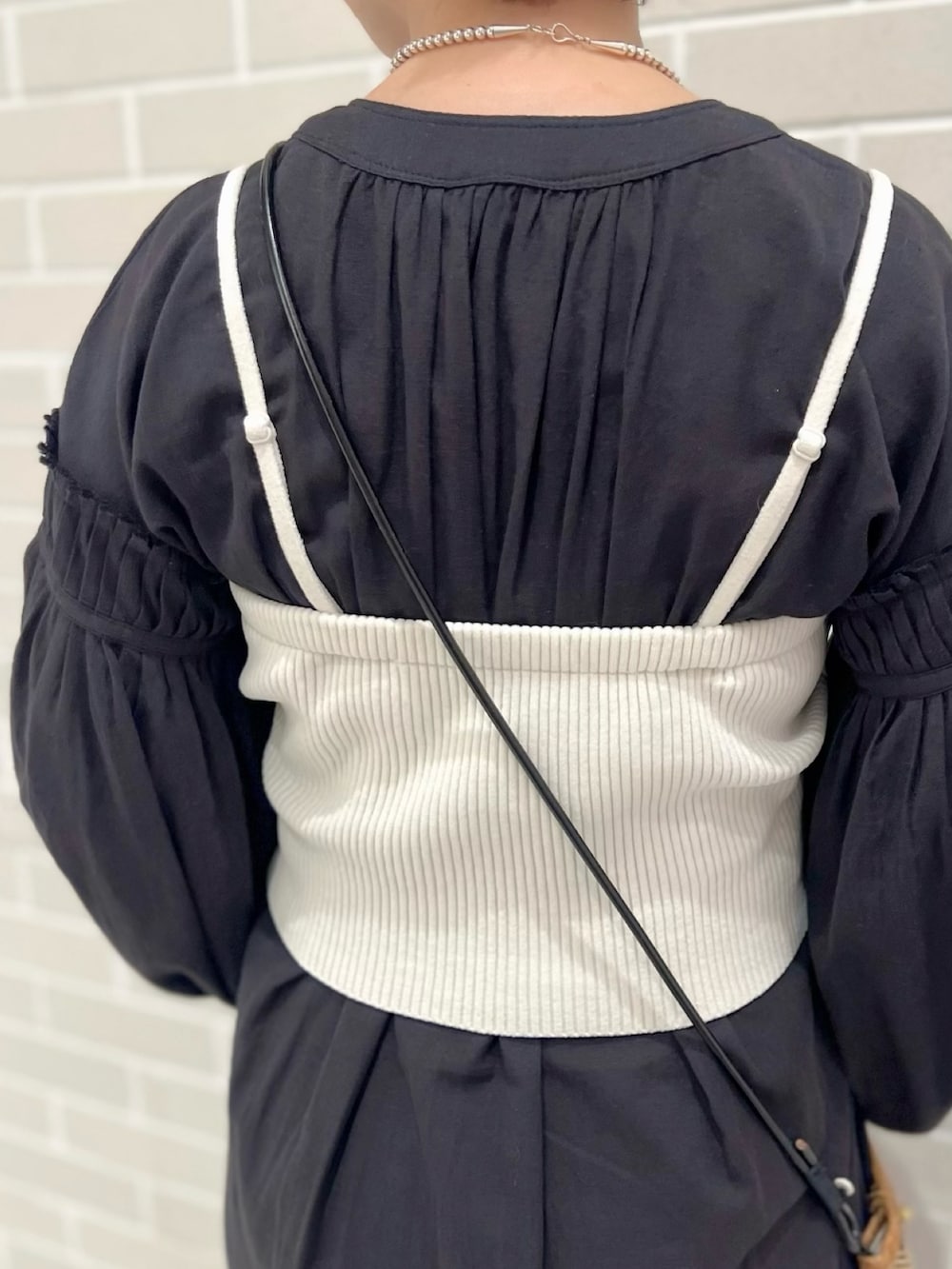 ブラック系のワンピース、ホワイト系のチューブトップ、ベージュ系のワンピースを着用したレディースの春コーディネートの4枚目の写真