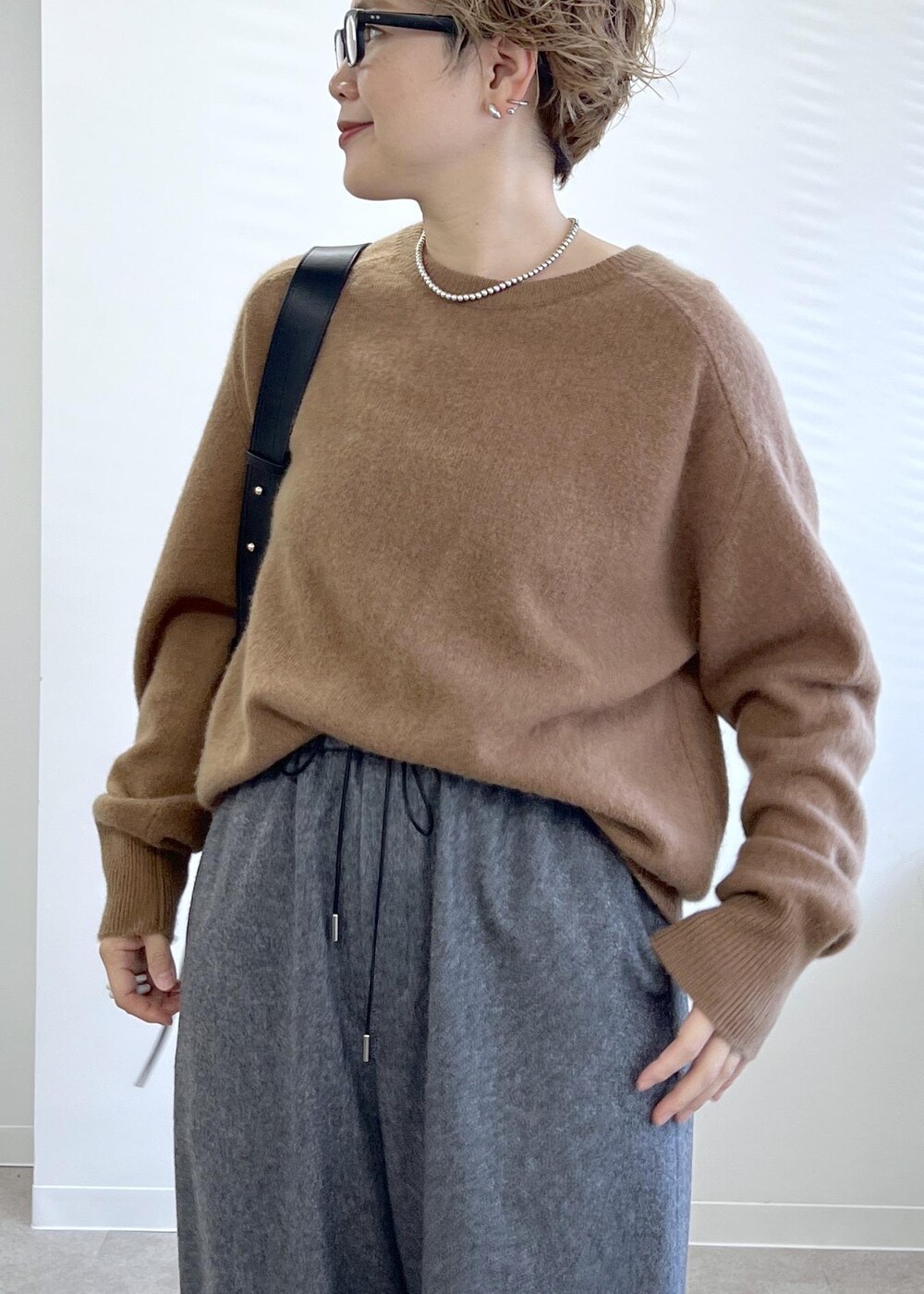 ブラック系のショルダーバッグ、グレー系のその他パンツ、ブラウン系のニット/セーターを着用したレディースの秋コーディネートの8枚目の写真