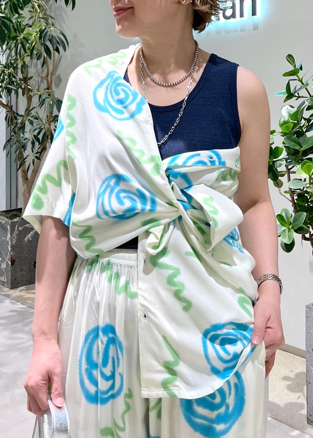 ブルー系のタンクトップ、シルバー系のショルダーバッグ、グレー系のサンダルを着用したレディースの春コーディネートの8枚目の写真