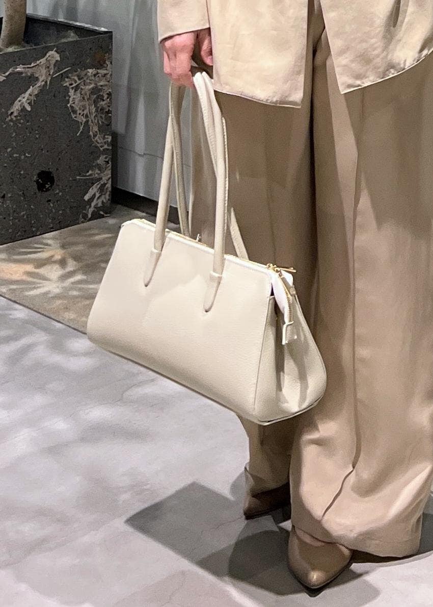 ベージュ系のその他パンツ、ベージュ系のシャツ/ブラウス、ホワイト系のボストンバッグを着用したレディースの春コーディネートの9枚目の写真