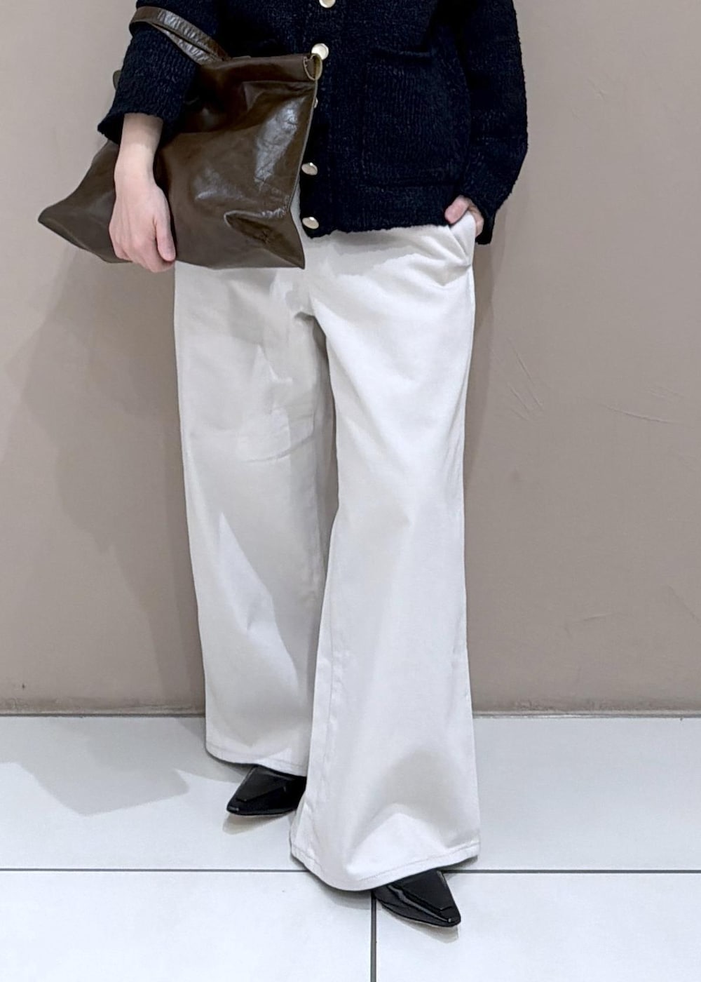 ブラック系のカーディガン/ボレロ、ホワイト系のサロペット/オーバーオール、ブラック系のローファーを着用したレディースの冬コーディネートの8枚目の写真