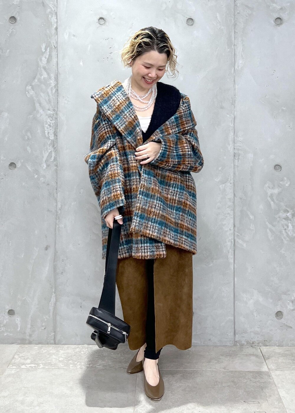 ブラック系のベスト、ブルー系のピーコート、ブラック系のボディバッグ/ウエストポーチを着用したレディースの秋コーディネートの8枚目の写真