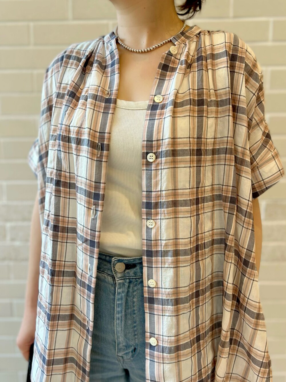 オレンジ系のシャツ/ブラウス、ブルー系のデニムパンツ、ブルー系のトートバッグを着用したレディースの夏コーディネートの3枚目の写真