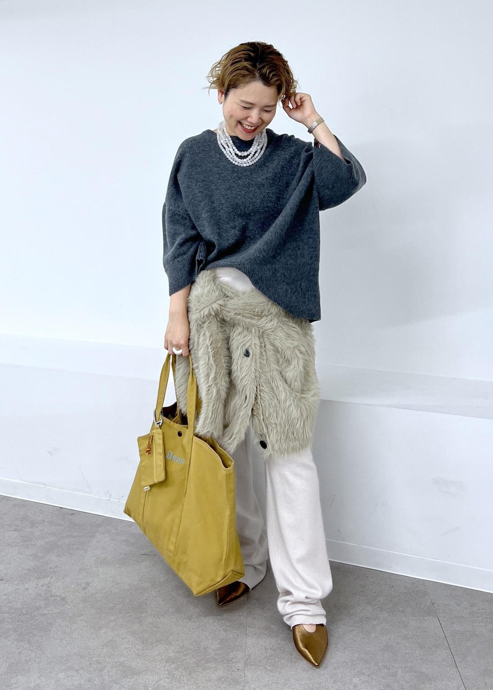 その他のパンプス、ベージュ系のカーディガン/ボレロ、ブラウン系のトートバッグを着用したレディースの秋コーディネートの3枚目の写真