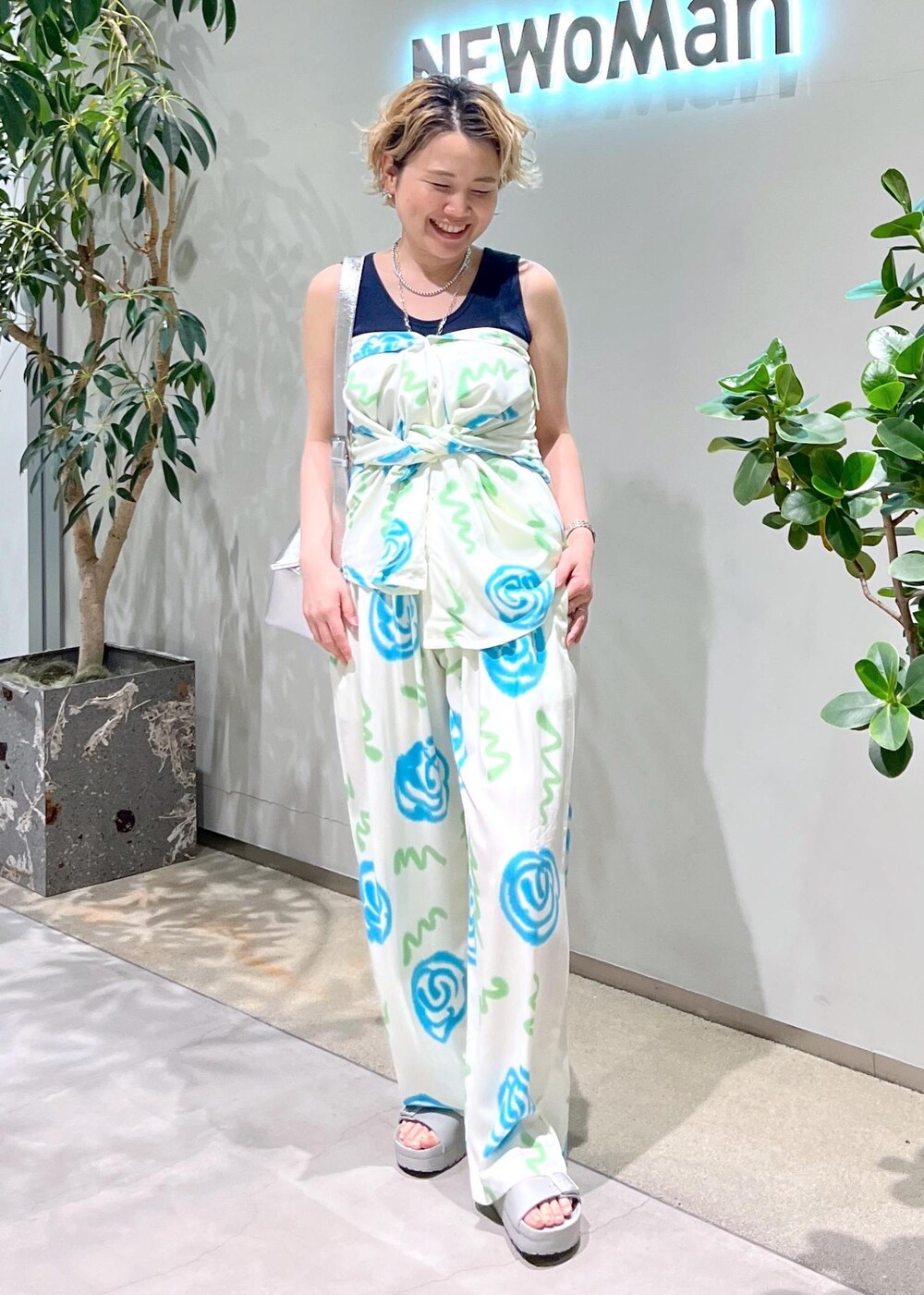 ブルー系のタンクトップ、シルバー系のショルダーバッグ、グレー系のサンダルを着用したレディースの春コーディネートの9枚目の写真