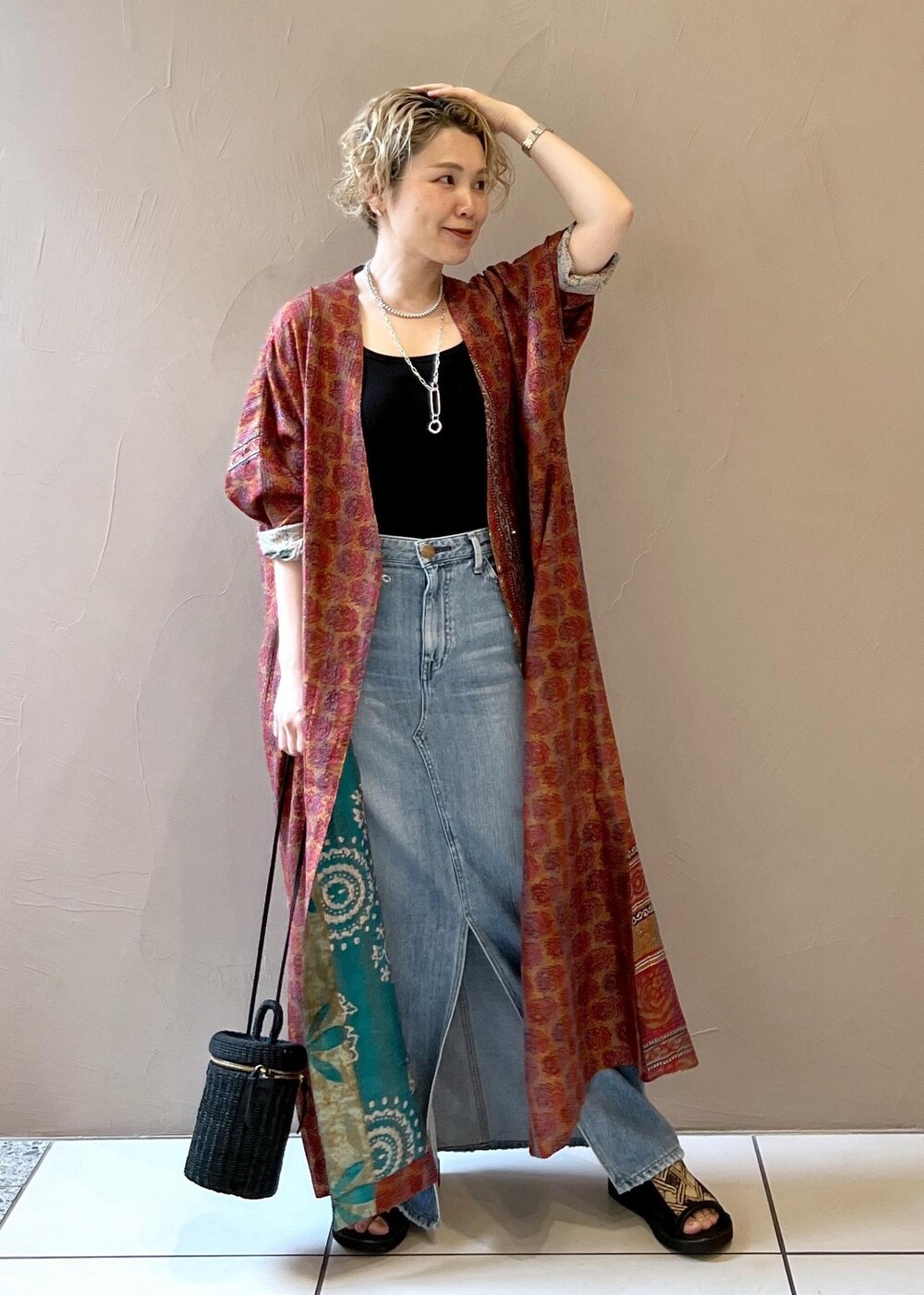 ブラック系のショルダーバッグ、ブラック系のタンクトップ、ブルー系のデニムスカートを着用したレディースの春コーディネートの2枚目の写真