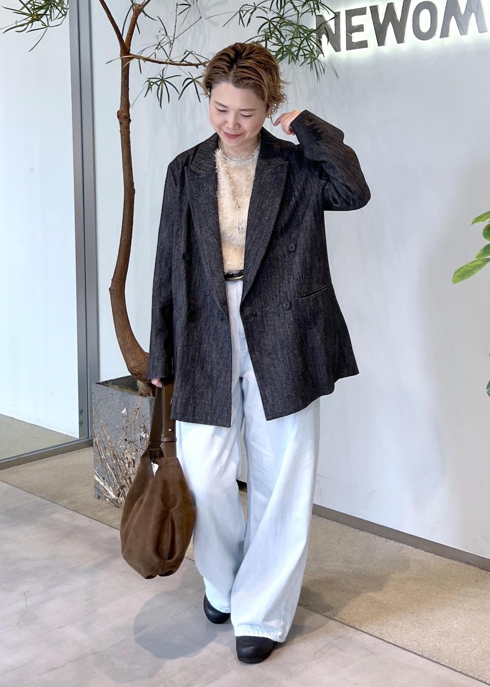 ブルー系のデニムパンツ、ベージュ系のその他トップス、ブラック系のテーラードジャケットを着用したレディースの秋コーディネートの4枚目の写真