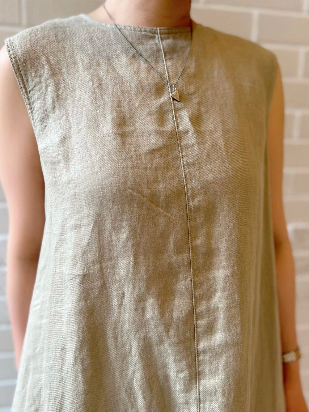 グリーン系のワンピース、ピンク系のハンドバッグ、ブラック系のサンダルを着用したレディースの夏コーディネートの3枚目の写真