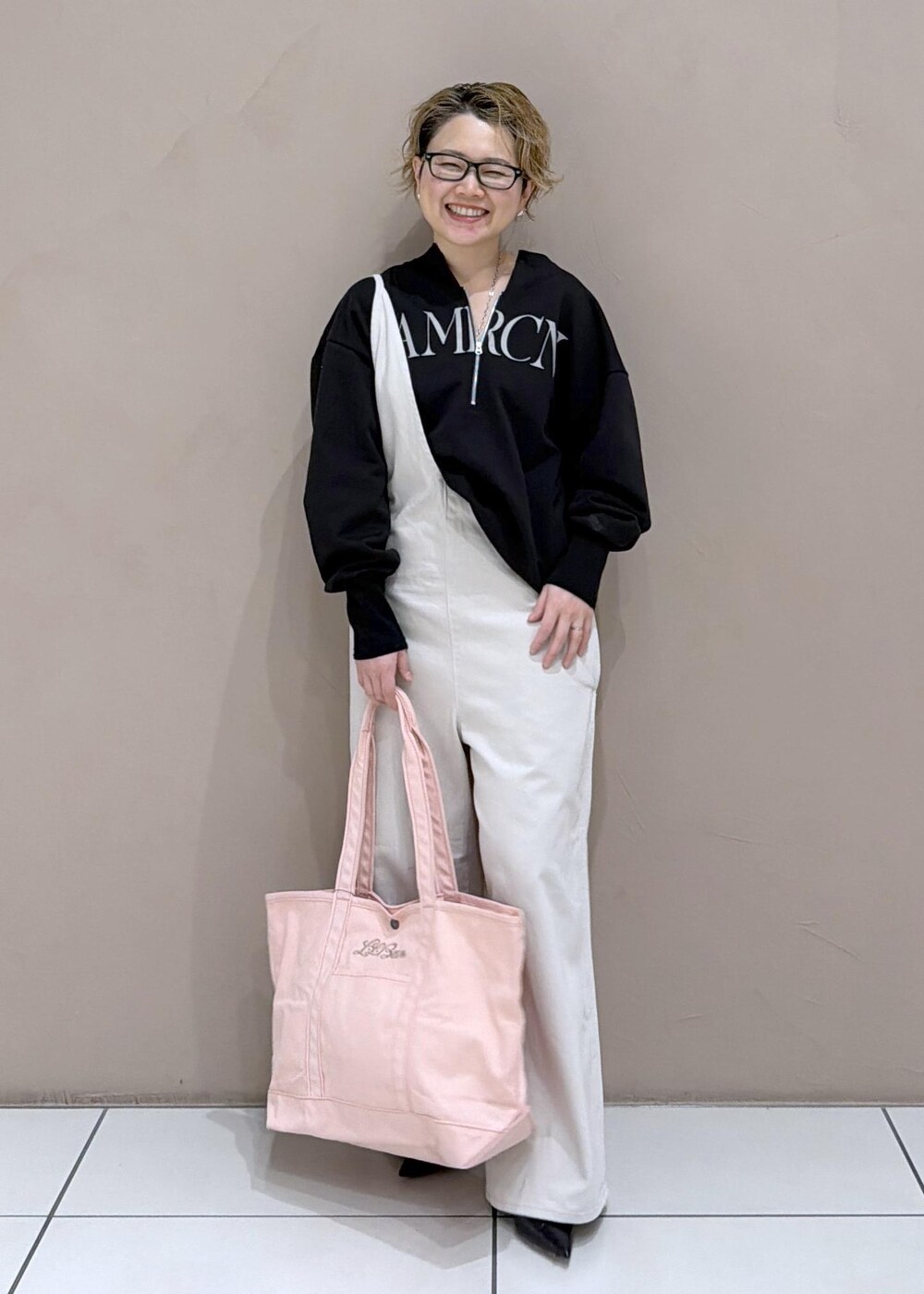 ブラック系のパンプス、ホワイト系のサロペット/オーバーオール、ブラック系のスウェットを着用したレディースの冬コーディネートの2枚目の写真