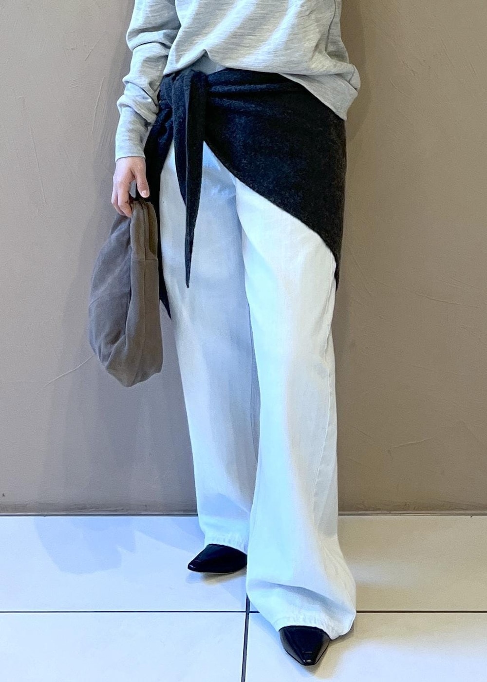 ブルー系のデニムパンツ、グレー系のハンドバッグ、ブラック系のパンプスを着用したレディースの秋コーディネートの8枚目の写真