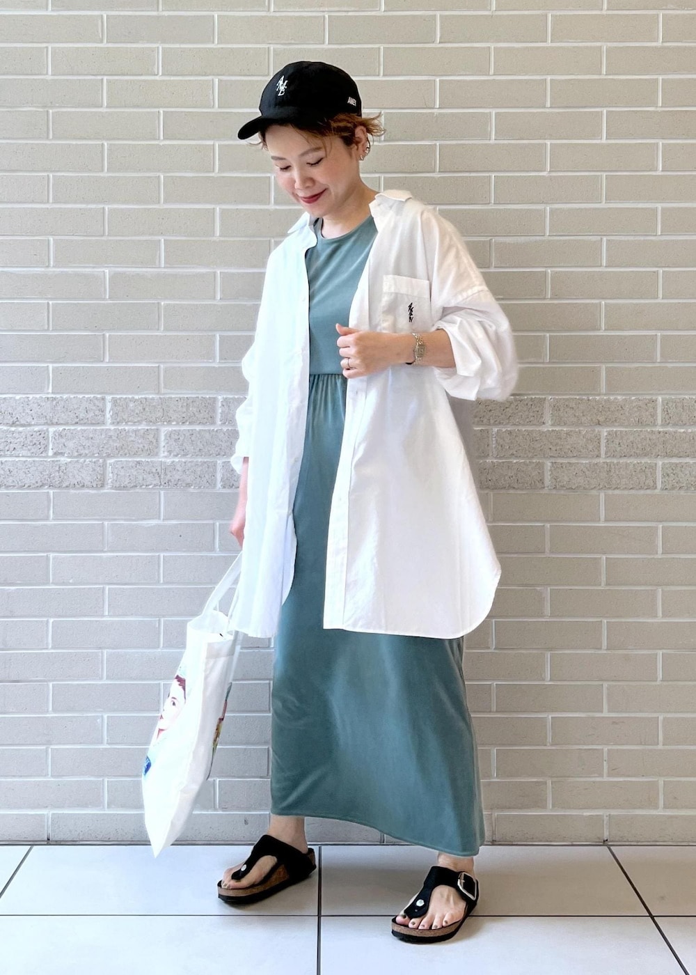 ホワイト系のシャツ/ブラウス、グリーン系のスカート、グリーン系のTシャツ/カットソーを着用したレディースの夏コーディネートの4枚目の写真