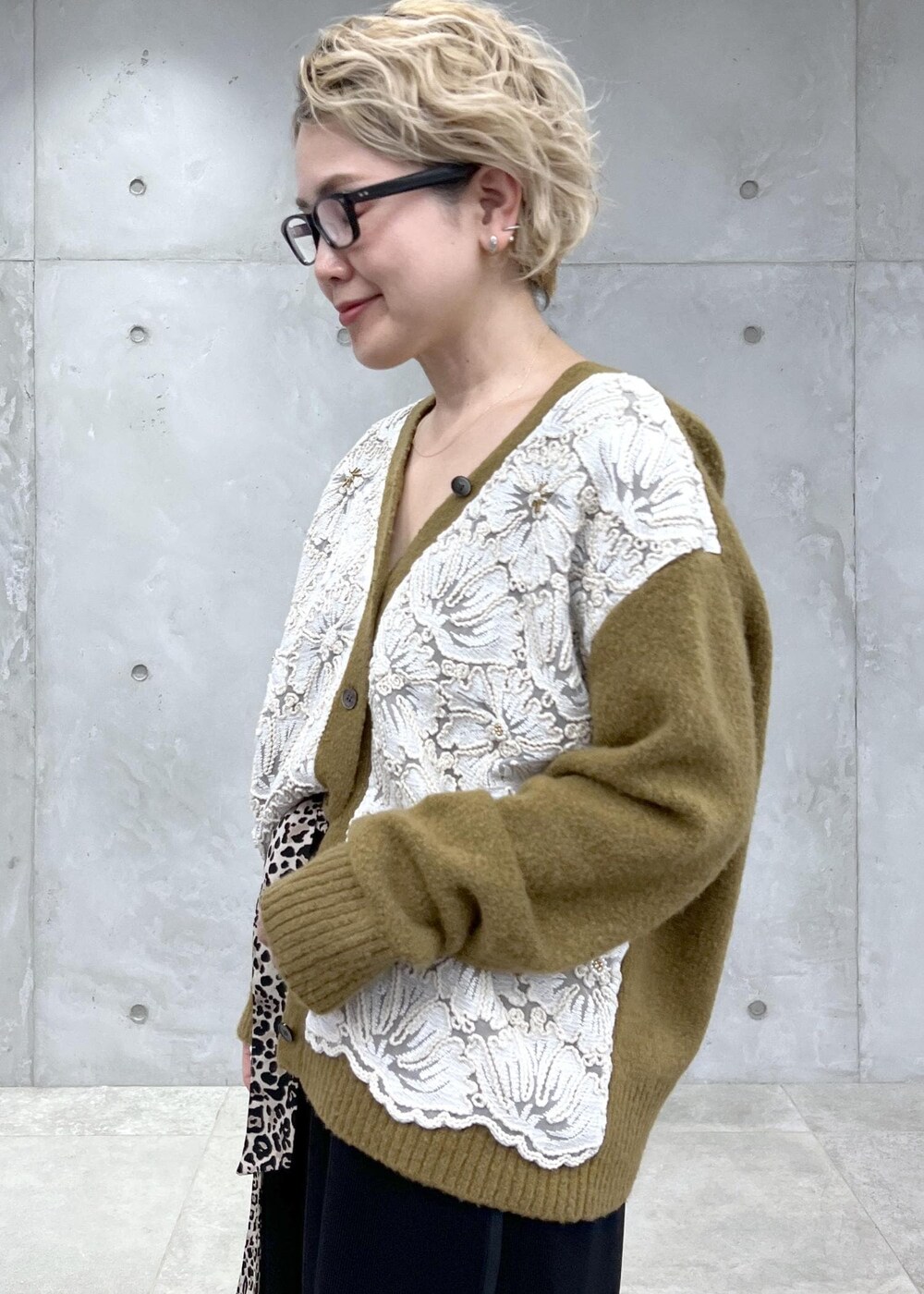 イエロー系のカーディガン/ボレロ、シルバー系のショルダーバッグ、ブラック系のその他パンツを着用したレディースの冬コーディネートの6枚目の写真