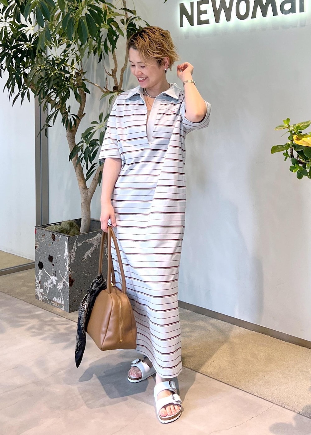 ブラウン系のボストンバッグ、ホワイト系のサンダル、ブルー系のワンピースを着用したレディースの夏コーディネートの2枚目の写真