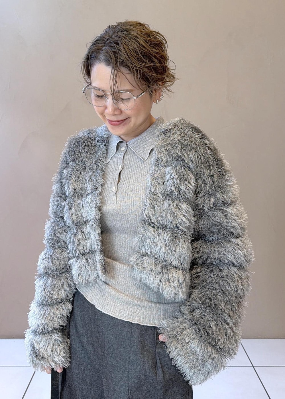 ブラック系のショルダーバッグ、グレー系のスラックス、グレー系のカーディガン/ボレロを着用したレディースの冬コーディネートの7枚目の写真