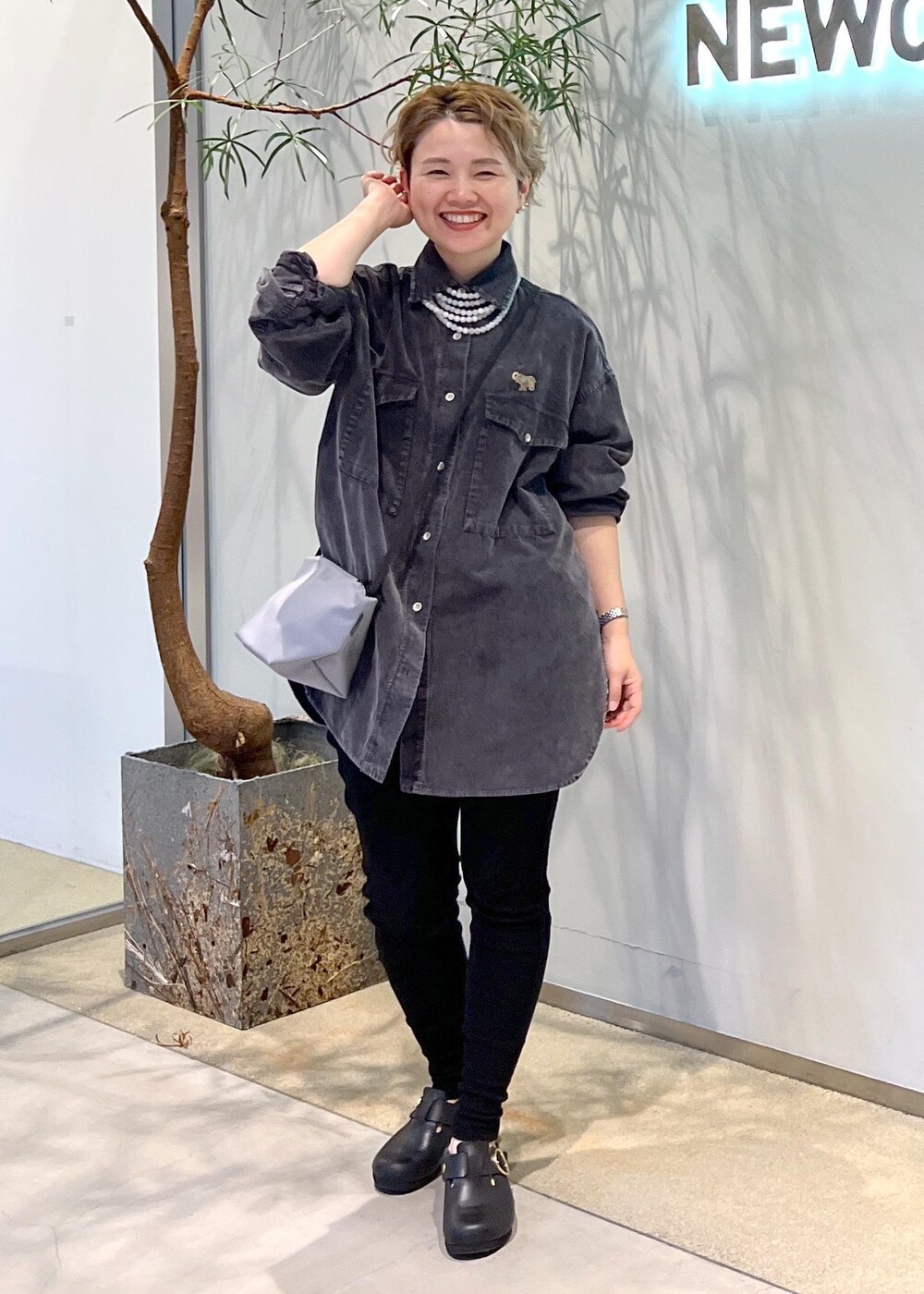 グレー系のシャツ/ブラウス、ブラック系のスニーカーを着用したレディースの秋コーディネートの2枚目の写真