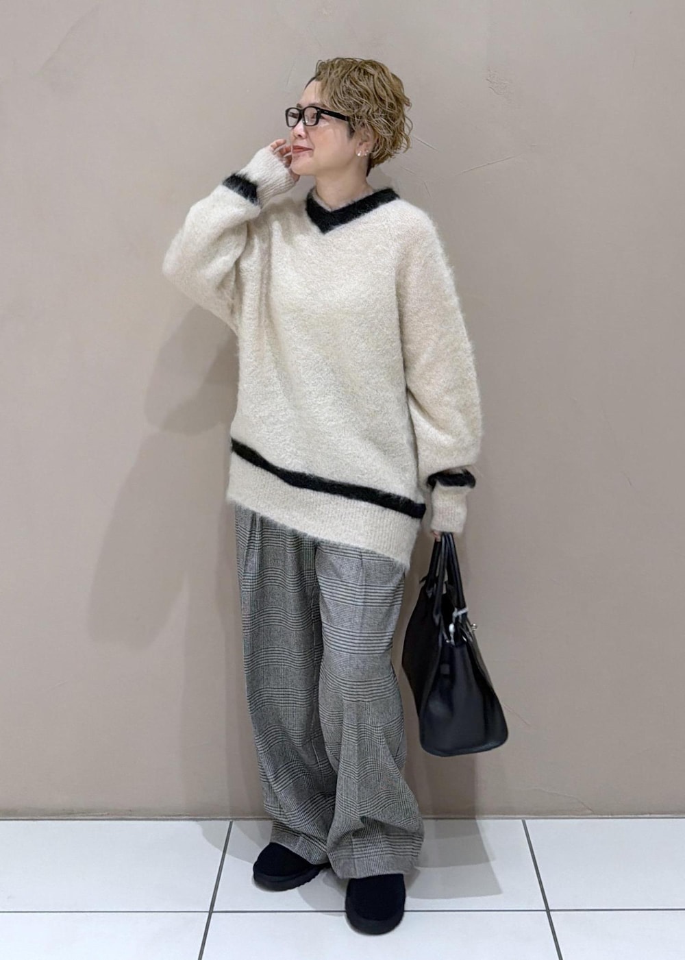 グレー系のスラックス、ブラック系のブーツを着用したレディースの冬コーディネートの5枚目の写真