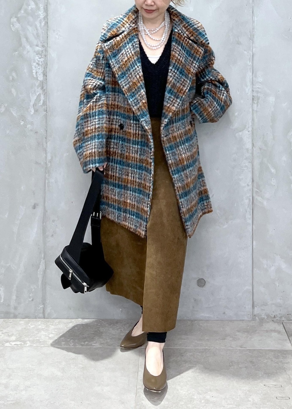 ブラック系のベスト、ブルー系のピーコート、ブラック系のボディバッグ/ウエストポーチを着用したレディースの秋コーディネートの7枚目の写真