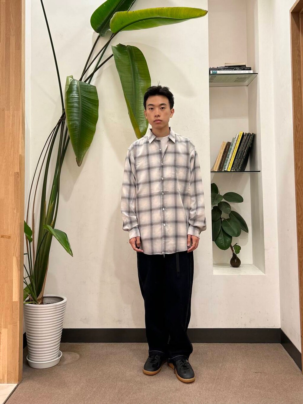 ブルー系のデニムパンツ、ホワイト系のTシャツ/カットソー、ブラック系のスニーカーを着用したメンズの夏コーディネートの2枚目の写真