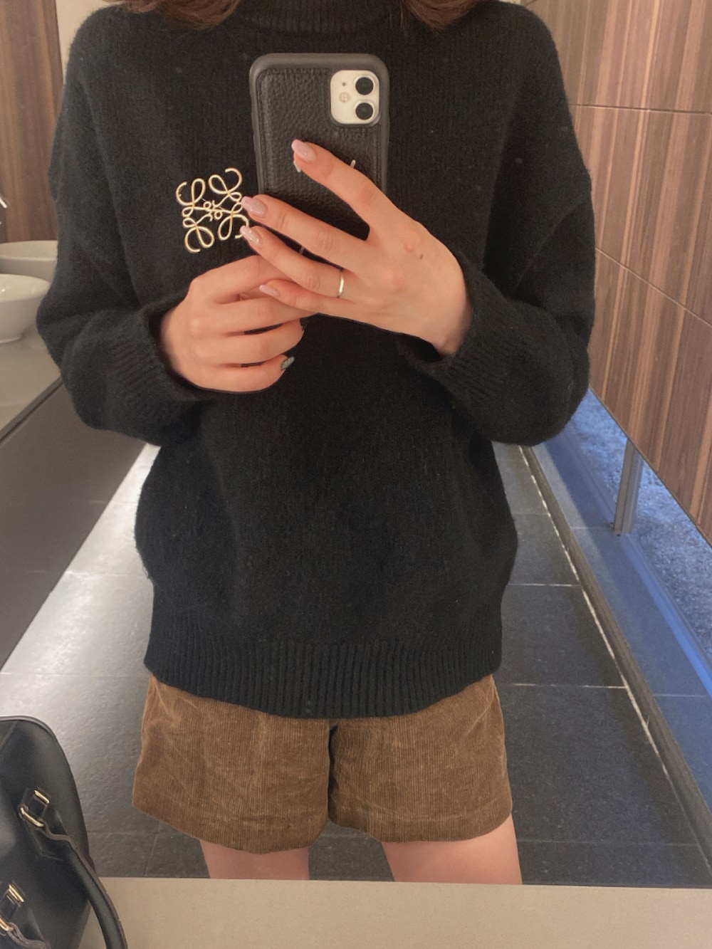 ブラック系のブーツ、ブラック系のニット/セーター、ブラック系のボストンバッグを着用したレディースの秋コーディネートの2枚目の写真