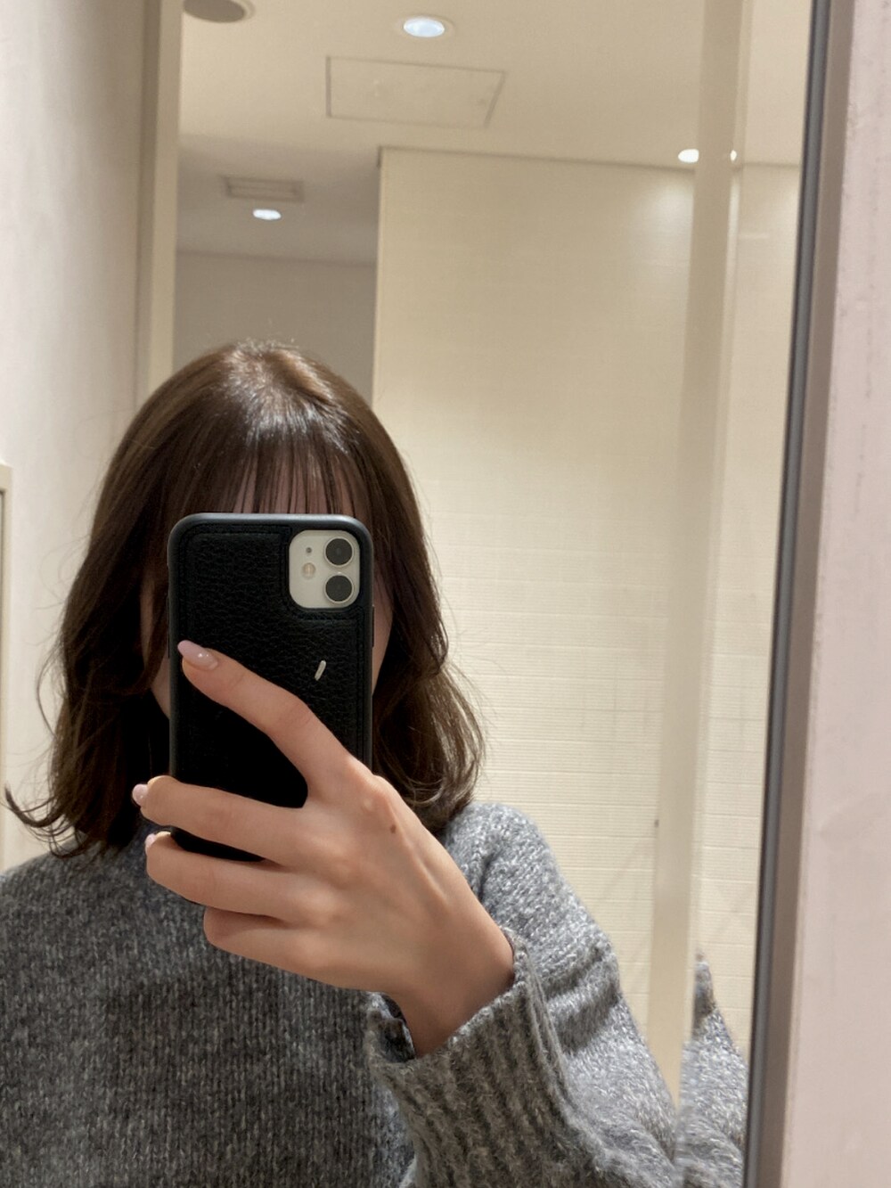 グレー系のニット/セーター、ブラック系のデニムパンツ、ブラック系のブーツを着用したレディースの秋コーディネートの2枚目の写真