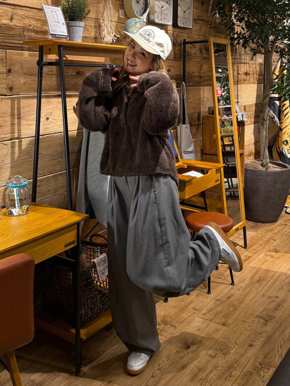 ブラウン系のポロシャツ、ホワイト系のキャップを着用したレディースの冬コーディネートの3枚目の写真