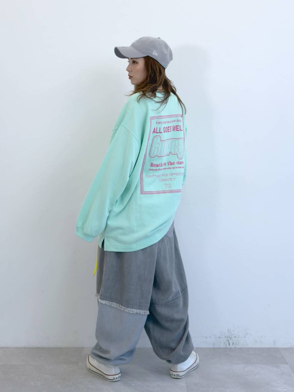 グレー系のデニムパンツ、グリーン系のTシャツ/カットソーを着用したレディースの冬コーディネートの2枚目の写真