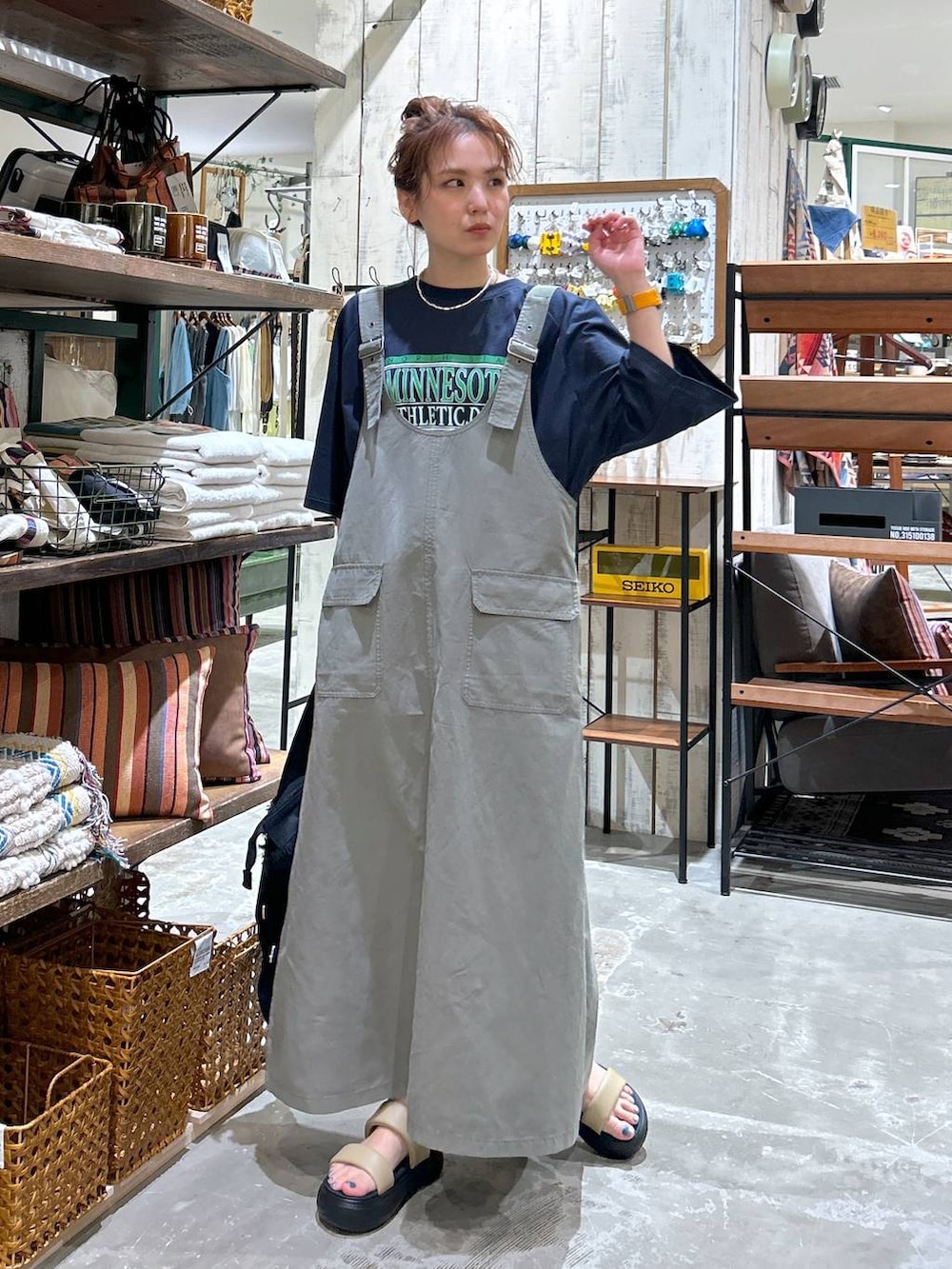 ブラック系のショルダーバッグ、イエロー系のサンダル、ブルー系のTシャツ/カットソーを着用したレディースの春コーディネートの2枚目の写真