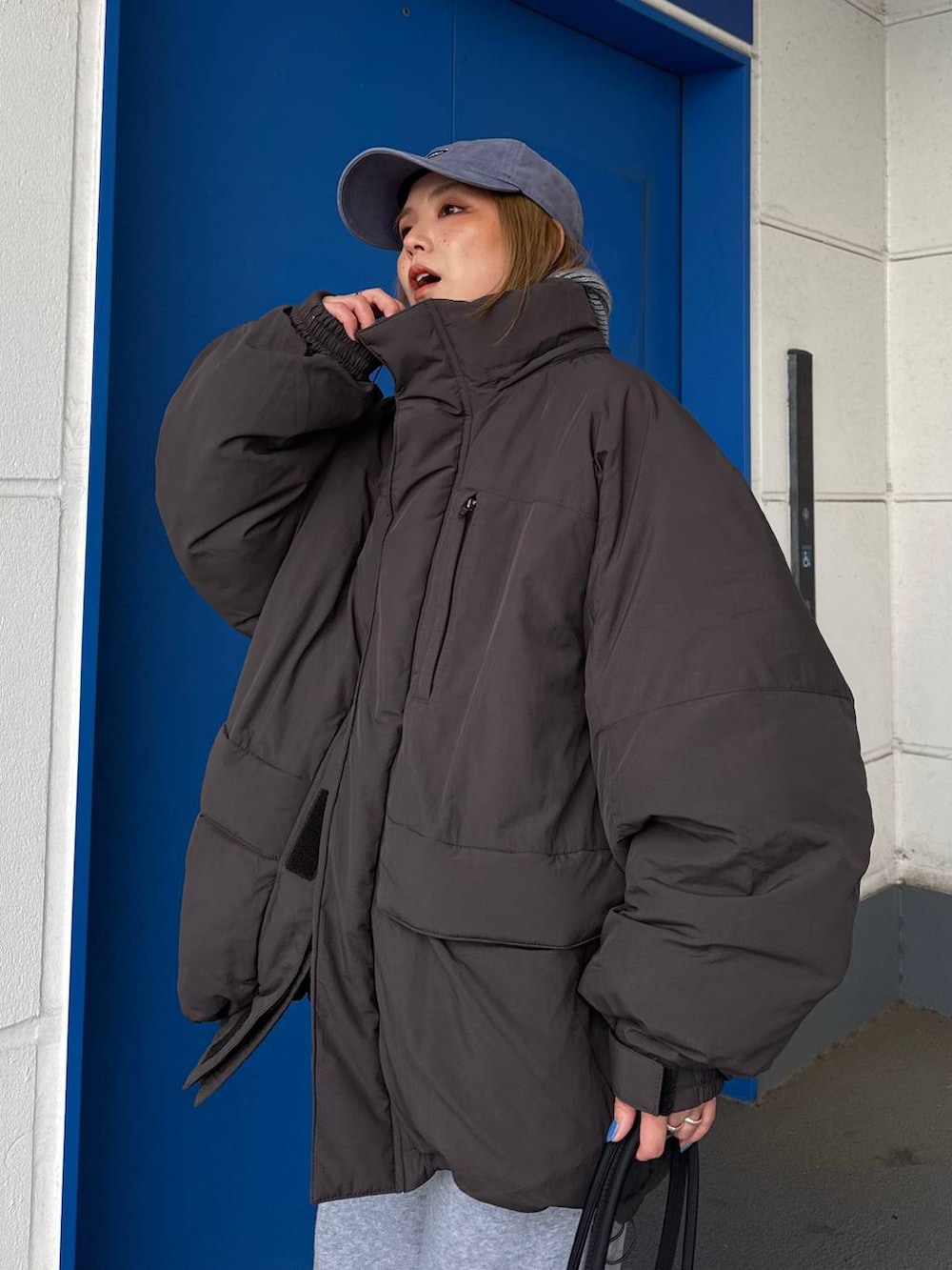 グレー系のダウンジャケット/コート、グレー系のスウェットパンツを着用したレディースの冬コーディネートの8枚目の写真