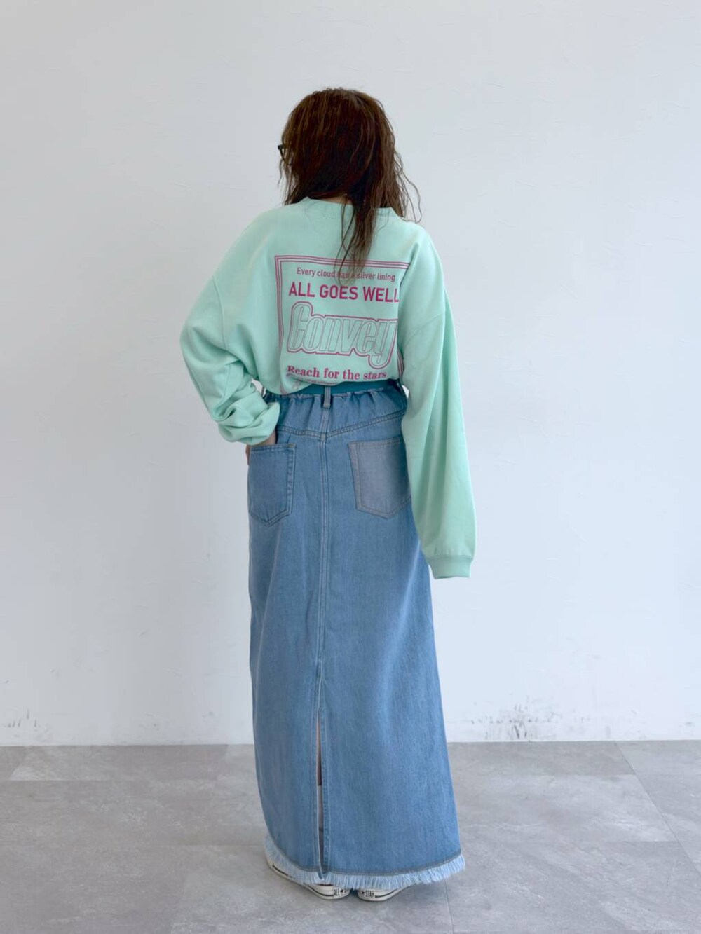 ブルー系のデニムスカート、グリーン系のTシャツ/カットソーを着用したレディースの冬コーディネートの5枚目の写真