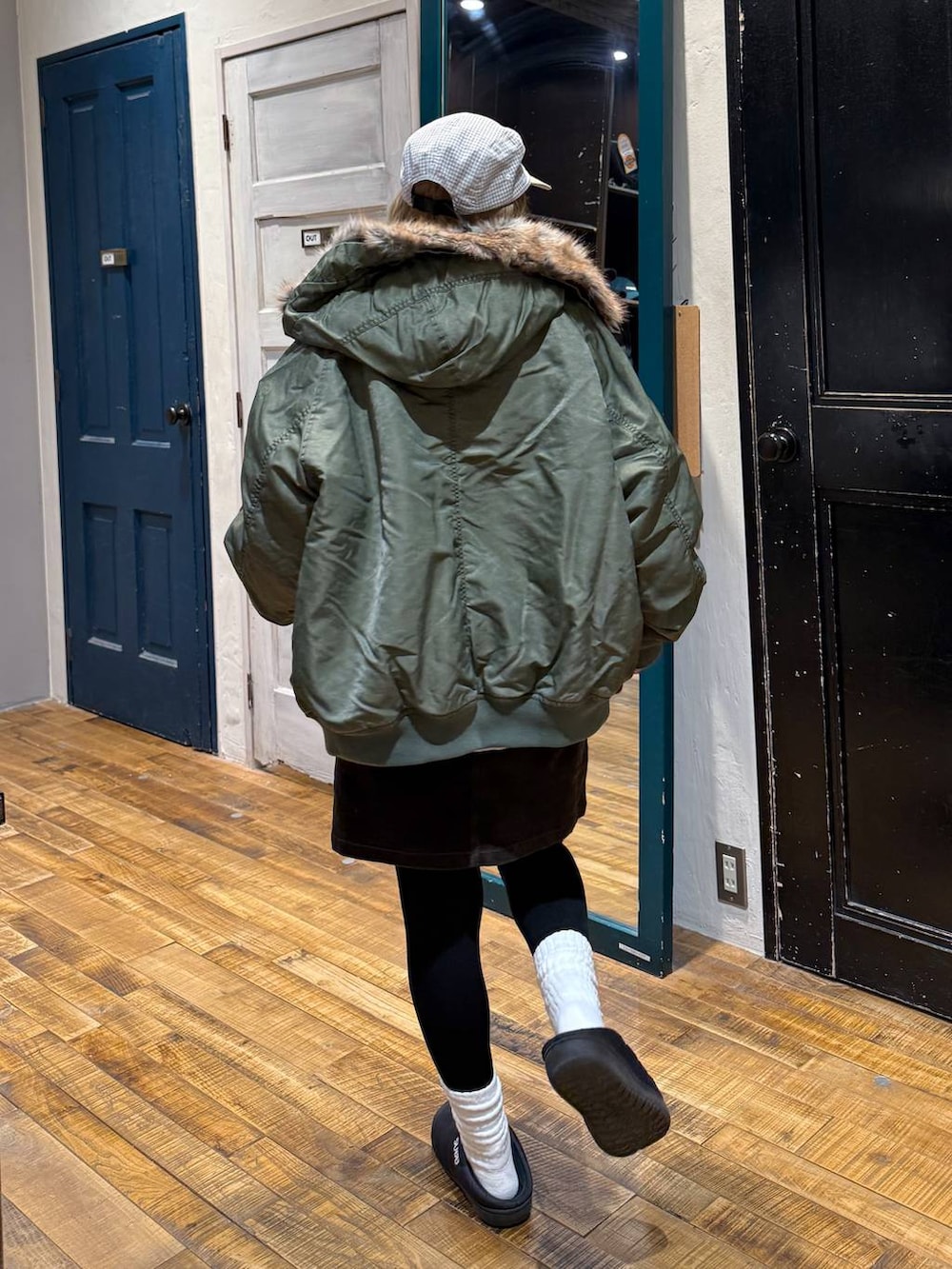 ブラウン系のスカート、グリーン系のブルゾン、レッド系のスウェットを着用したレディースの冬コーディネートの4枚目の写真