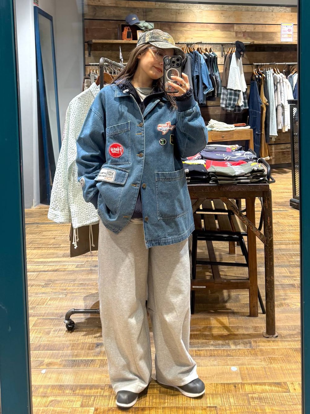 グレー系のスウェットパンツ、グリーン系のキャップを着用したレディースの春コーディネートの3枚目の写真