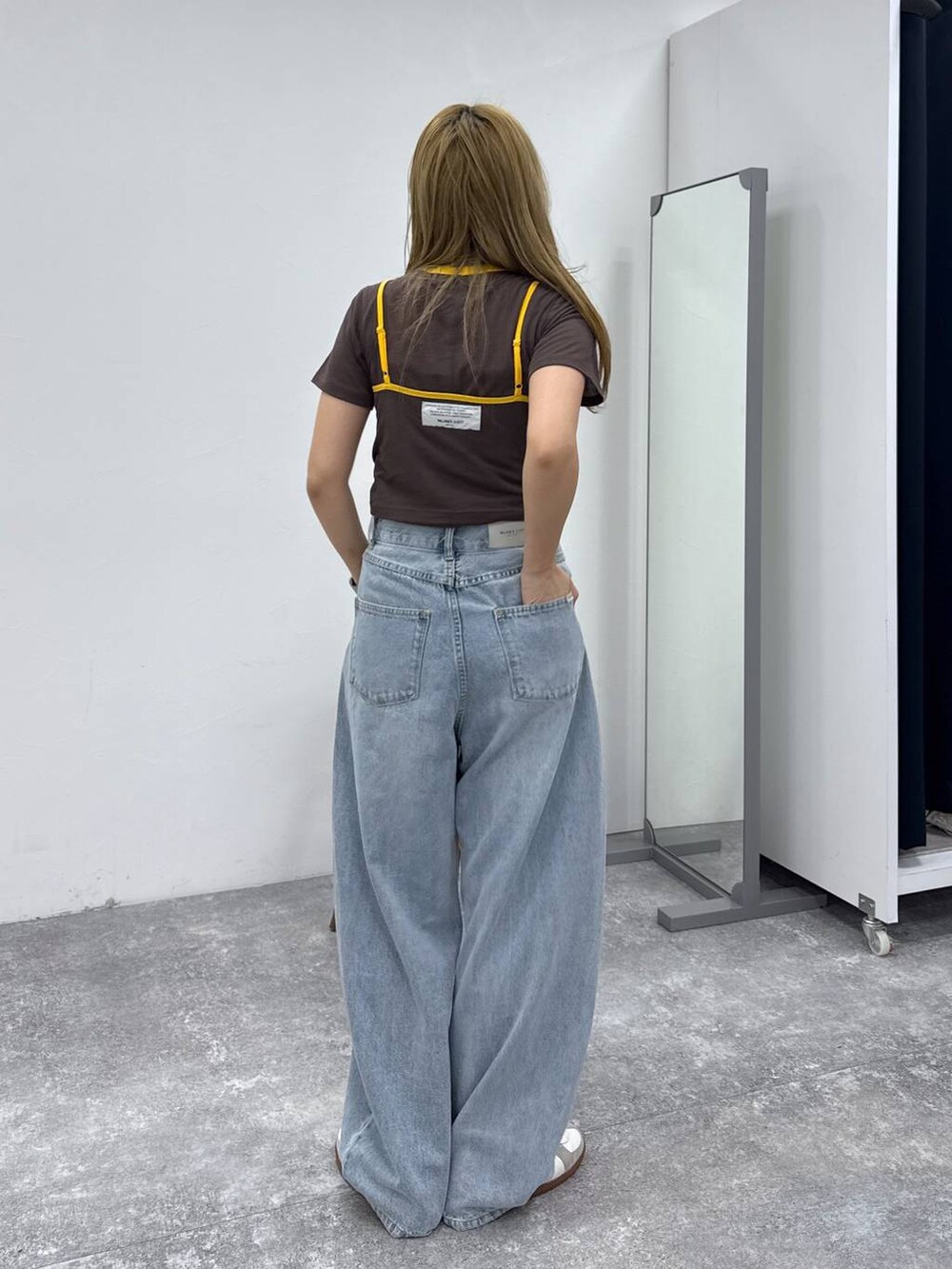 ベージュ系のスニーカー、ブラウン系のTシャツ/カットソー、ブルー系のデニムパンツを着用したレディースの春コーディネートの4枚目の写真