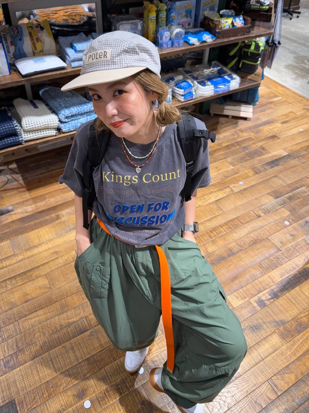 グリーン系のカーゴパンツ、その他のTシャツ/カットソー、イエロー系のキャップを着用したレディースの夏コーディネートの2枚目の写真