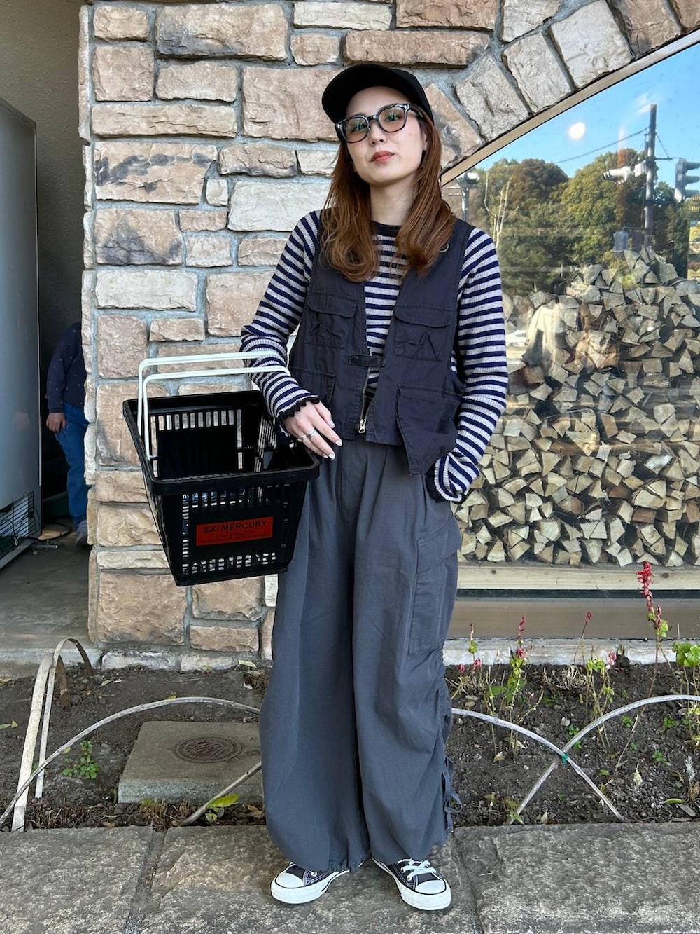 グレー系のベスト、ベージュ系のTシャツ/カットソー、ブラック系のキャップを着用したレディースの春コーディネートの2枚目の写真