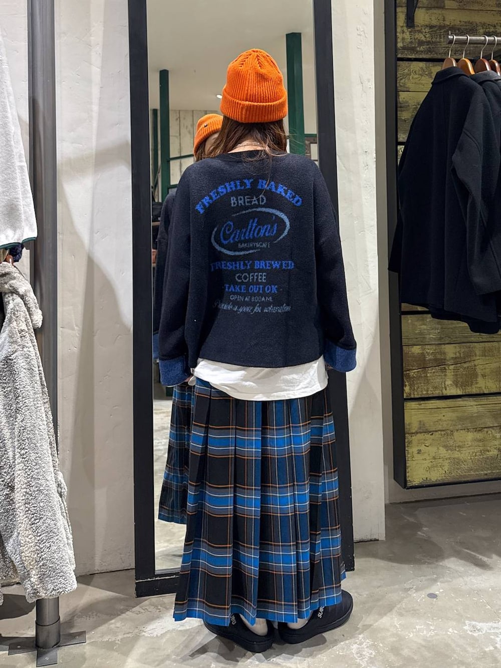 ブラック系のスカート、ホワイト系のTシャツ/カットソー、ブラック系のニット/セーターを着用したレディースの冬コーディネートの2枚目の写真