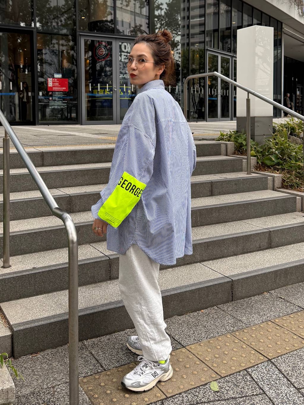 グレー系のスウェットパンツ、グリーン系のミリタリージャケットを着用したレディースの春コーディネートの4枚目の写真