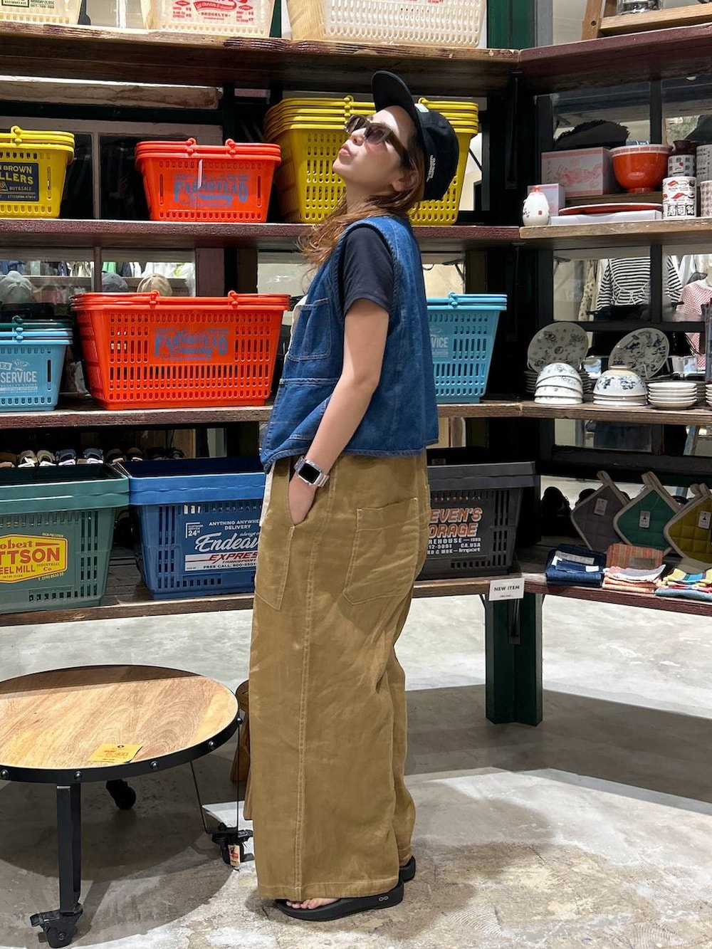 ブラック系のTシャツ/カットソー、ブルー系のベスト、ブラック系のサンダルを着用したレディースの春コーディネートの2枚目の写真