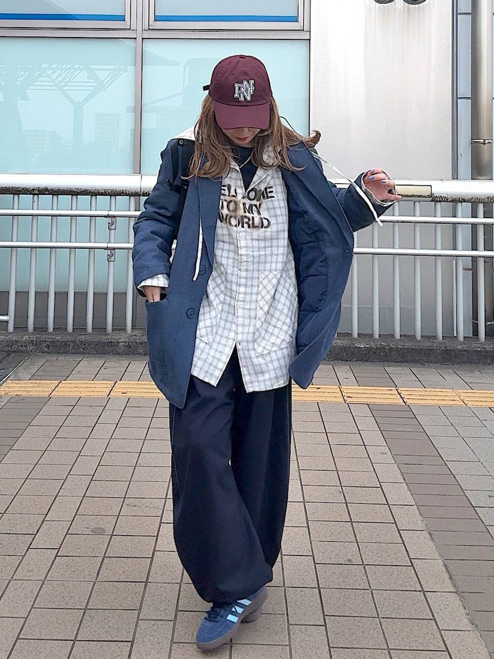 ブルー系のテーラードジャケット、ベージュ系のシャツ/ブラウス、レッド系のキャップを着用したレディースの冬コーディネートの2枚目の写真