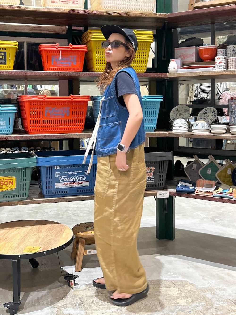 ブラック系のTシャツ/カットソー、ブルー系のベスト、ブラック系のサンダルを着用したレディースの春コーディネートの3枚目の写真