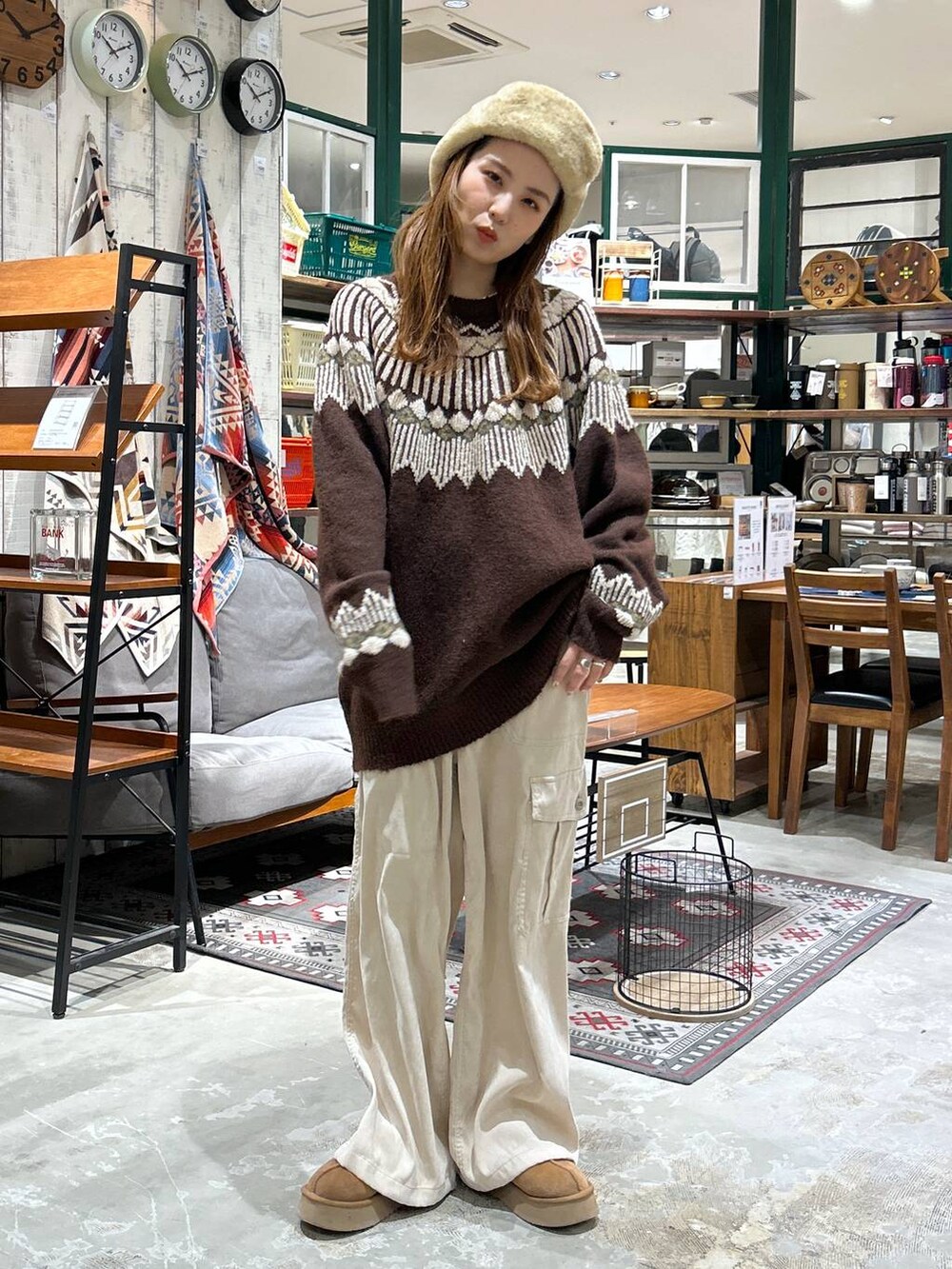 ベージュ系のカーゴパンツ、ブラウン系のニット/セーター、ベージュ系のキャップを着用したレディースの冬コーディネートの3枚目の写真