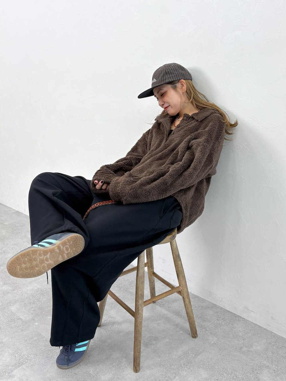 ブラック系のその他パンツ、ブラウン系のポロシャツ、ブラウン系のベルトを着用したレディースの秋コーディネートの2枚目の写真