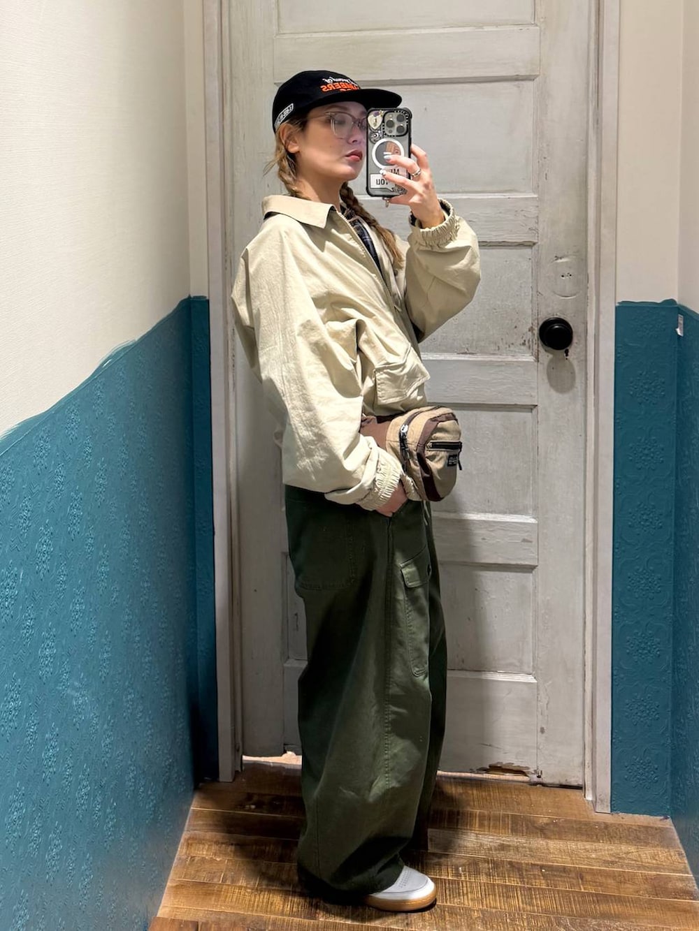 イエロー系のブルゾン、ブルー系のTシャツ/カットソー、ベージュ系のボディバッグ/ウエストポーチを着用したレディースの冬コーディネートの2枚目の写真