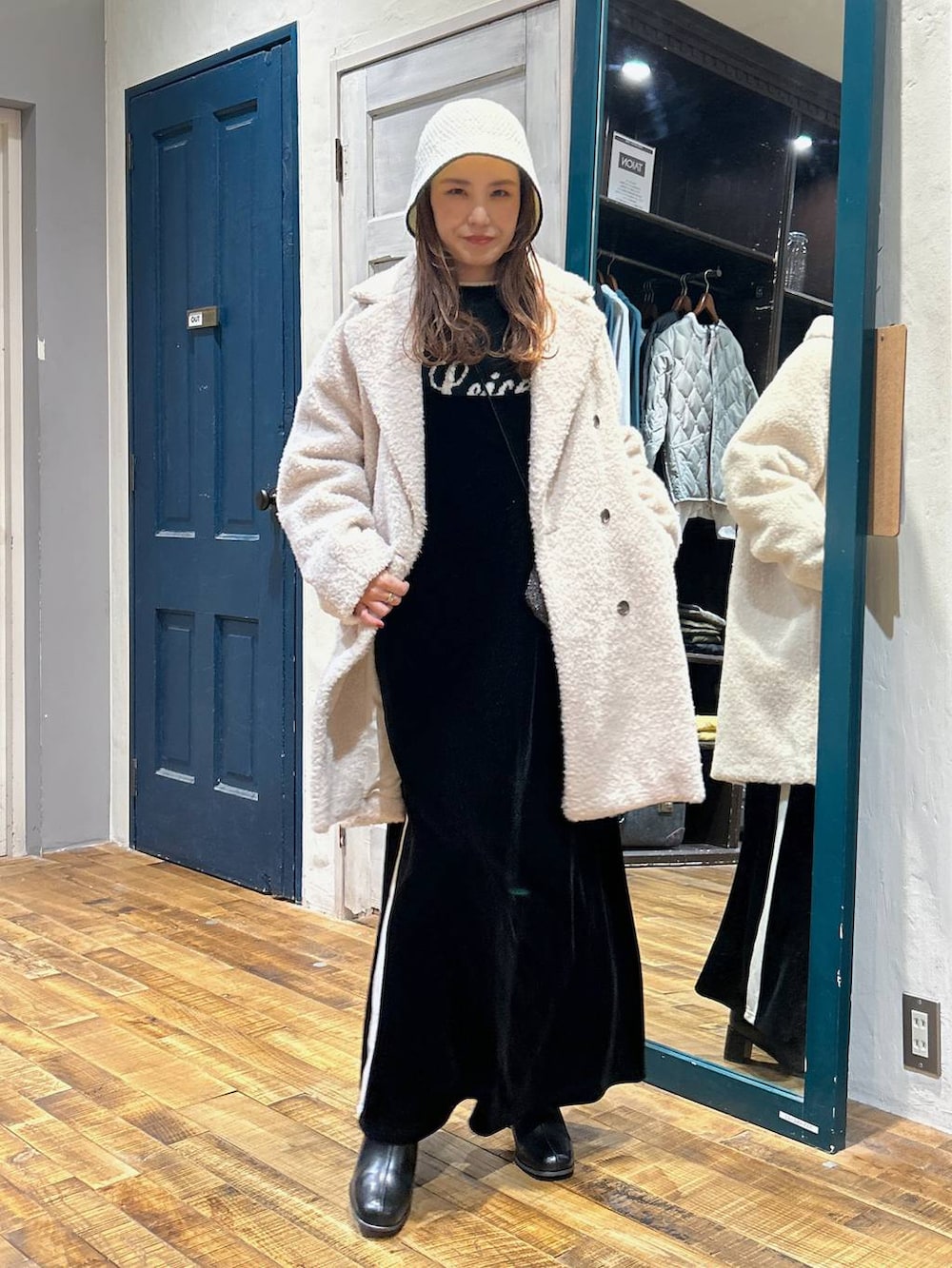 ベージュ系のその他アウター、ブラック系のブーツ、ブラック系のニット/セーターを着用したレディースの冬コーディネートの2枚目の写真