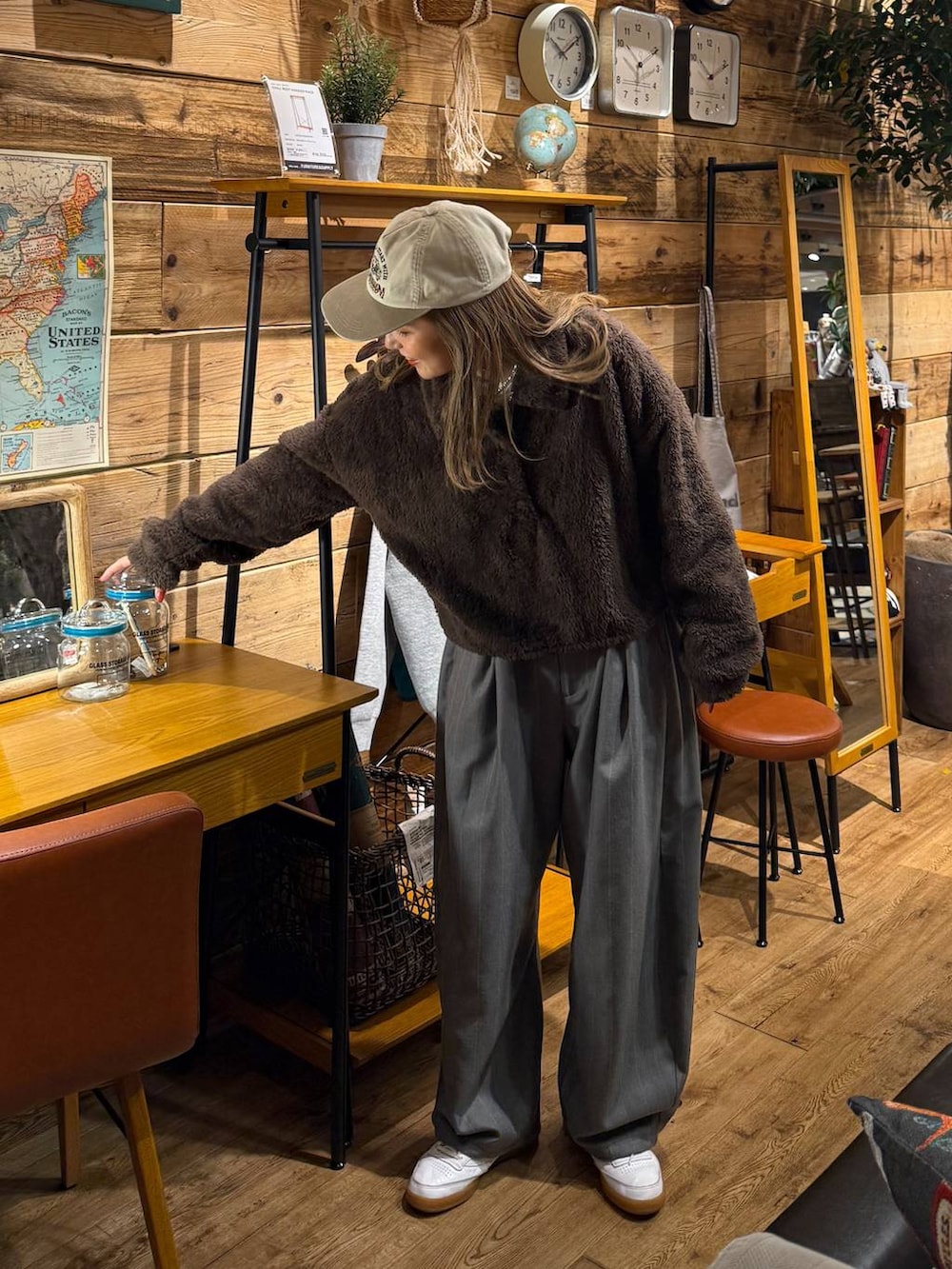 ブラウン系のポロシャツ、ホワイト系のキャップを着用したレディースの冬コーディネートの5枚目の写真