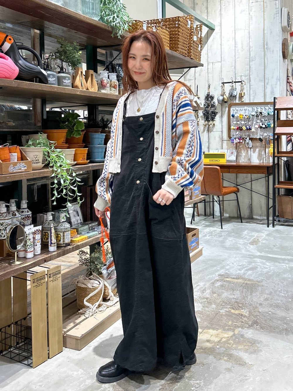 ブラック系のローファー、オレンジ系のカーディガン/ボレロ、グレー系のショルダーバッグを着用したレディースの冬コーディネートの2枚目の写真