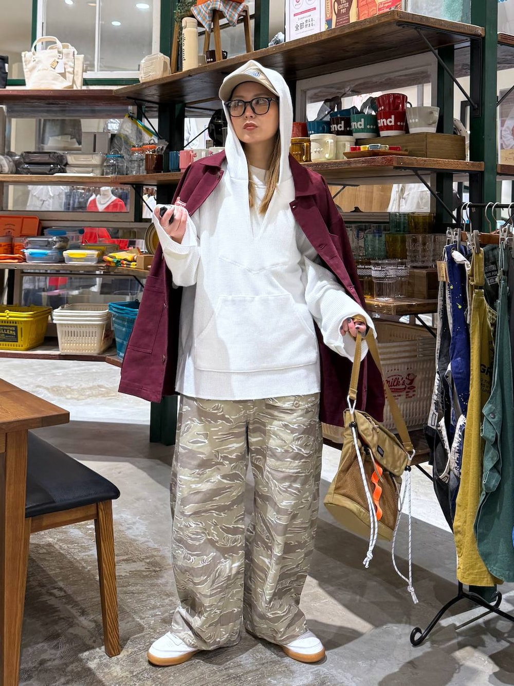 ホワイト系のパーカー、ベージュ系のキャップを着用したレディースの春コーディネートの2枚目の写真